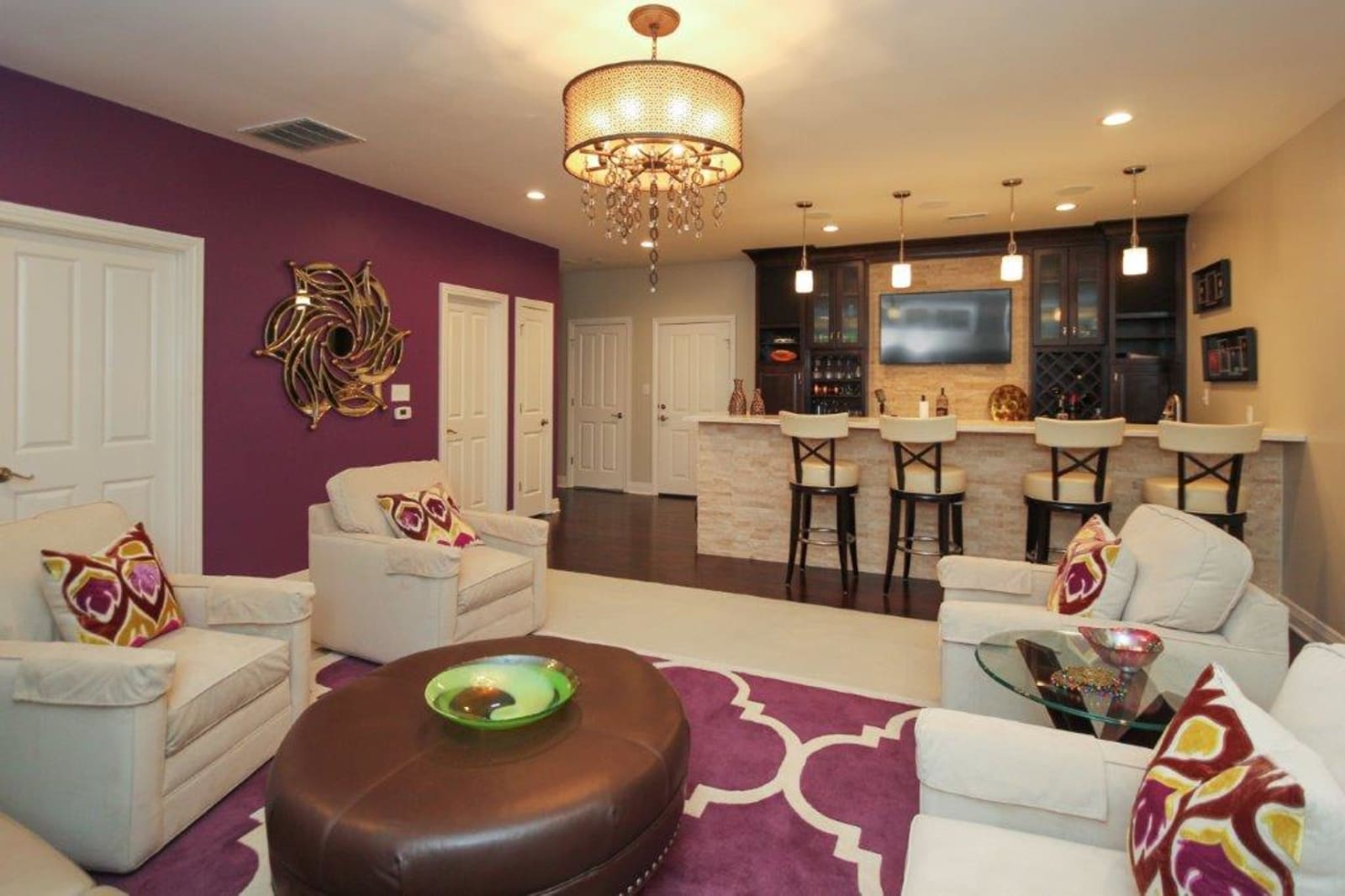 Built-in home bar with upper glass display cabinets and a stone countertop
